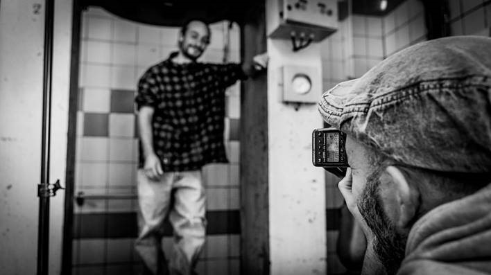 Photographe prenant le portrait plein pieds d'un homme en noir et blanc